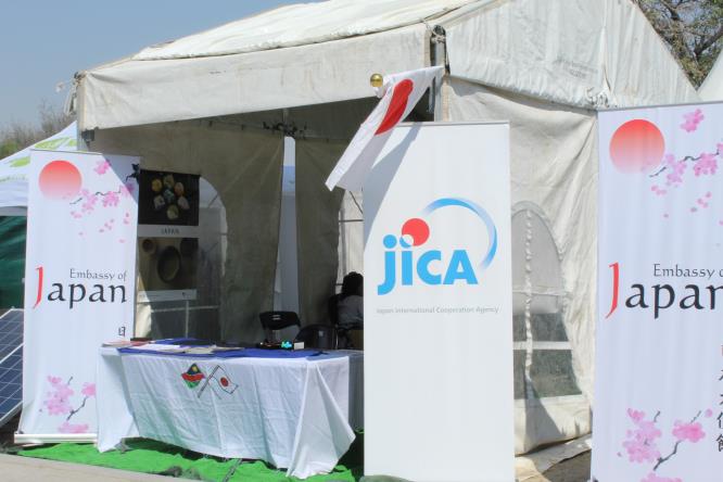 Trade fair booth with Japanese cultural displays and visitors