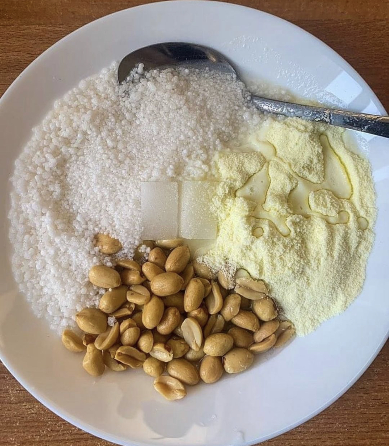 Groundnuts, sugar packets and powdered milk on a surface